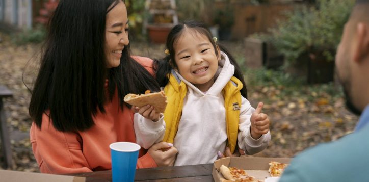 family-eating-pizza-outdoors-side-view-2